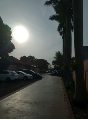 Fotografia da fachada principal da escola com os alunos reunidos na entrada.